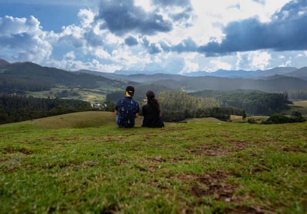 couple sitting in green valley appreciating nature